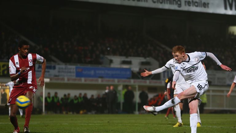 Sam Clucas of Hereford United shoots as Sido Jombati of Cheltenham Town looks on during the FA Cup Second Round Replay.