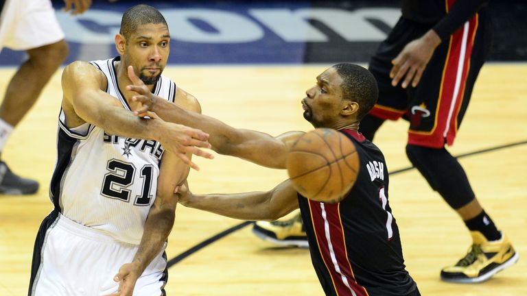 Tim Duncan of the San Antonio Spurs passes under pressure from Chris Bosh of the Miami Heat during game 5 of the NBA finals