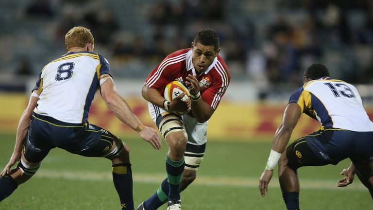 Toby Faletua of the Lions is tackled by Peter Kimlin (L) and Tevita Kuridrani of the Brumbies