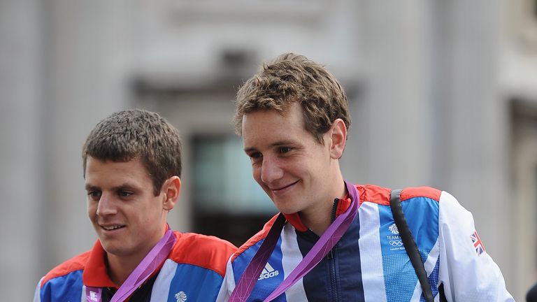 Triathletes Jonathan Brownlee and Alistair Brownlee show their medals to the crowd during the London 2012 Victory Parade for Team GB and Paralympic GB athletes on September 10, 2012 in London