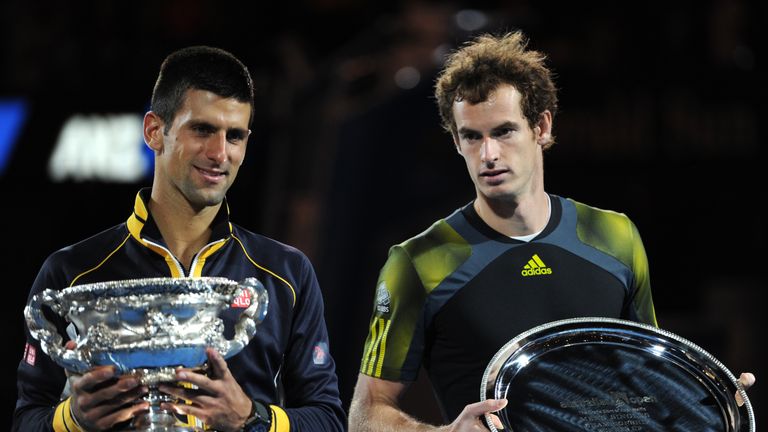 Serbia's Novak Djokovic (L) poses with the trophy after victory in his men's singles final against Britain's Andy Murray (R) on day fourteen of the Australian Open tennis tournament in Melbourne on January 27, 2013