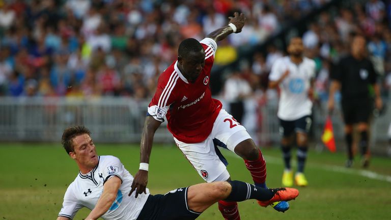 Mamadou Hady Barry of South China is tackled by Scott Parker of Tottenhan Hotspur.