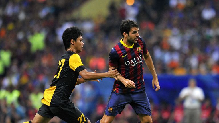 Malaysia football player Fadhli Shas (L) fights for the ball with Barcelona football player Cesc Fabregas during a friendly football match between Spanish football club Barcelona and Malaysia XI at the Shah Alam Stadium in Shah Alam, on the outskirts of Kuala Lumpur on August 10, 2013. AFP PHOTO / MOHD RASFAN        (Photo credit should read MOHD RASFAN/AFP/Getty Images)