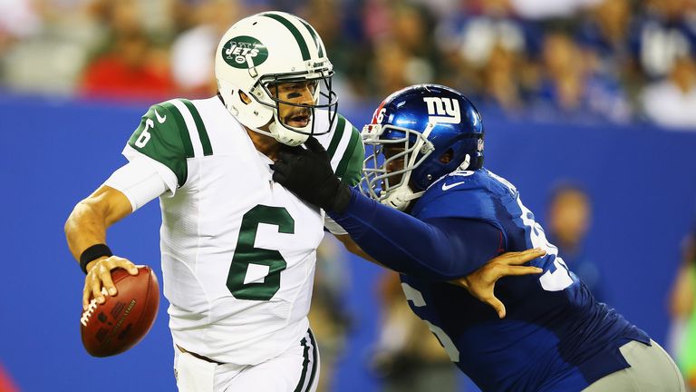 Mark Sanchez of the New York Jets is sacked by  Marvin Austin of the New York Giants.