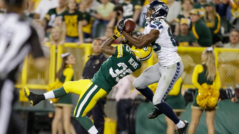 Stephen Williams of the Seattle Seahawks takes the ball away from Loyce Means of the Green Bay Packers at Lambeau Field