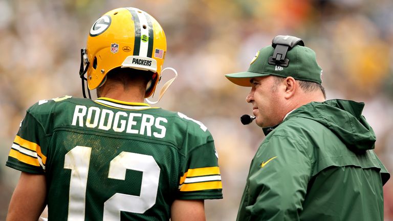Aaron Rodgers of the Green Bay Packers confers with head coach Mike McCarthy