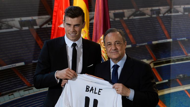 Gareth Bale of Real Madrid (L) poses with his new jersey next to Real Madrid's President Florentino Perez during his presentation at the Santiago Bernabeu stadium in Madrid on September 2, 2013. 
