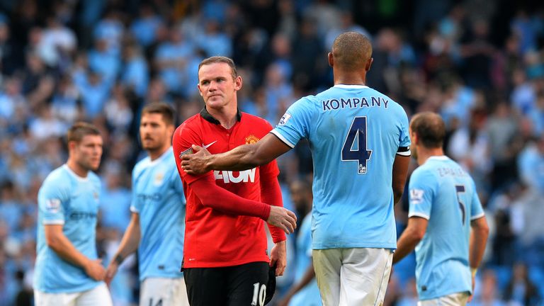 Manchester City's Belgian midfielder Vincent Kompany (R) shakes hands with Manchester United's English striker Wayne Rooney (L) after the English Premier League football match between Manchester City and Manchester United at the Etihad Stadium in Manchester, northwest England, on September 22, 2013. AFP PHOTO / PAUL ELLISnnRESTRICTED TO EDITORIAL USE. No use with unauthorized audio, video, data, fixture lists, club/league logos or live services. Online in-match use limited to 45 images, no video emulation. No use in betting, games or single club/league/player publications.        (Photo credit should read PAUL ELLIS/AFP/Getty Images)