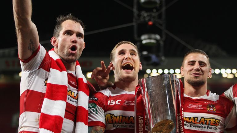 Sam Tomkins of Wigan Warriors with the trophy alongside Pat Richards and Michael Mcilorum after their 30-16 victory in the Super League Grand Final against Warrington Wolves at Old Trafford