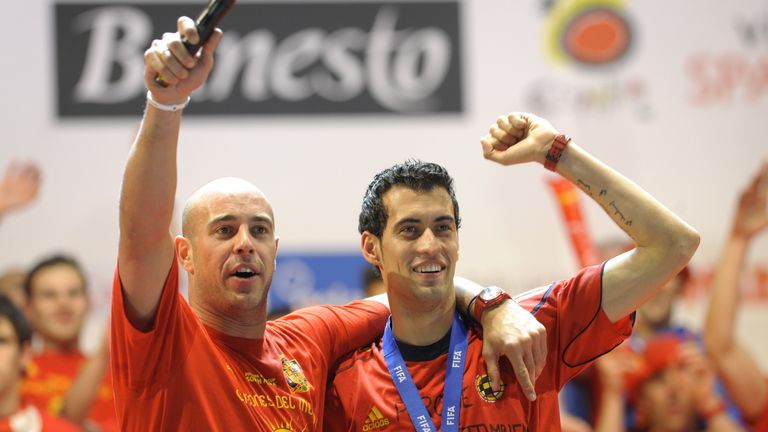 Spain's goalkeeper Pepe Reina (L) and Spain's midfielder Sergio Busquets celebrate on a stage set up for the Spanish team victory ceremony in Madrid on July 12, 2010 a day after they won the 2010 FIFA football World Cup match against the Netherlands in Johannesburg.      