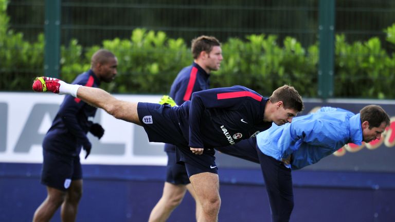 England midfielder Steven Gerrard (C) does stretching exercises during a training session at London Colney on October 10, 2013. England face Montenegro at Wembley in a 2014 World Cup qualifier on October 11, 2013. 