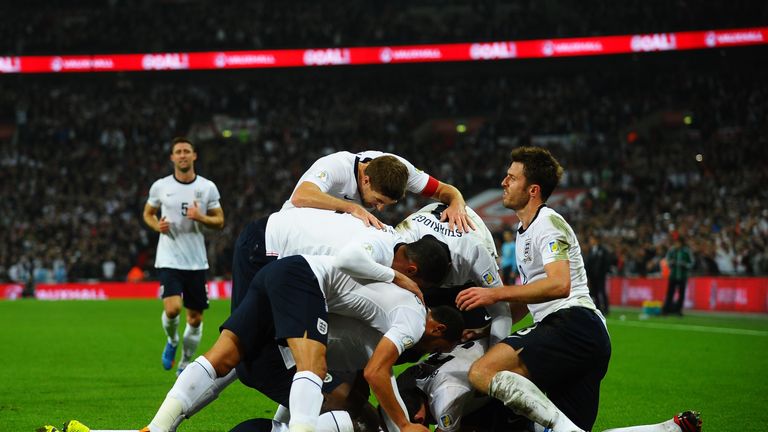 Wayne Rooney of England celebrates with team mates after scoring his team's opening goal during the FIFA 2014 World Cup Qualifying Group H match between England and Poland at Wembley Stadium