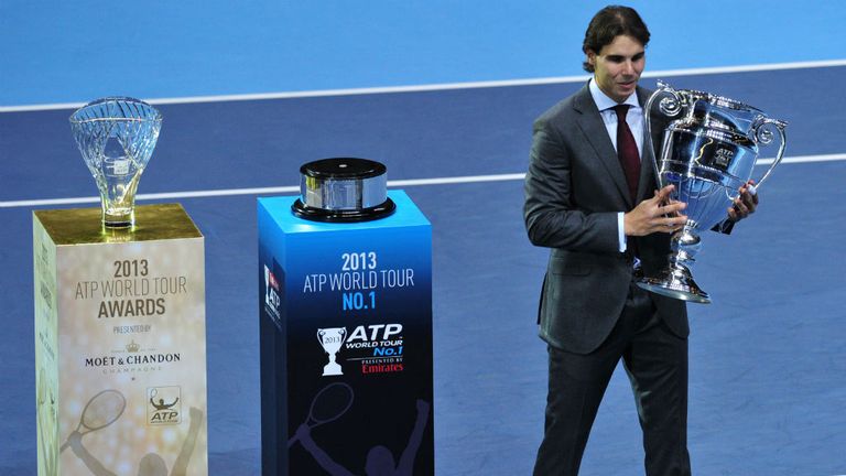 Spains Rafael Nadal poses with the 2013 ATP World Number One trophy as the 2013 ATP Comeback Player of the Year award L sits on its plinth on the sixth day of the ATP World Tour Finals tennis tournament in London
