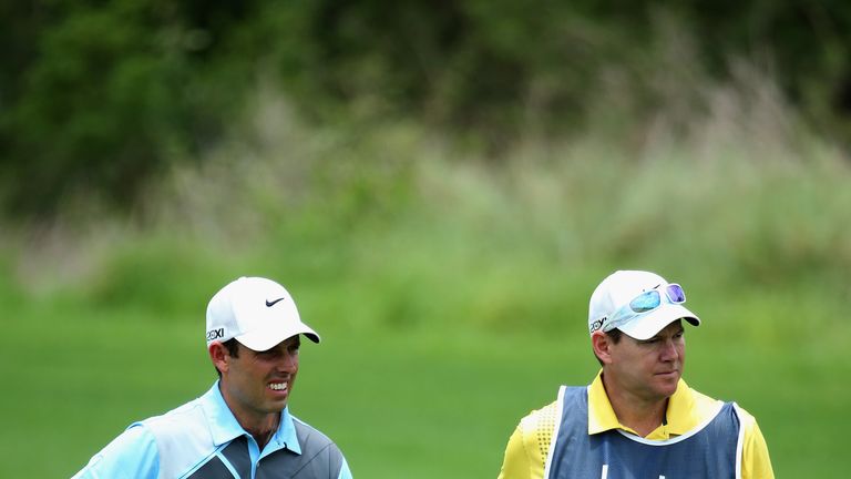 Charl Schwartzel of South Africa stands with caddie Glen Murray during the second round of the Alfred Dunhill Championship