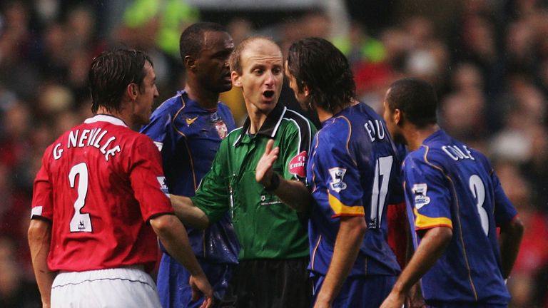 MANCHESTER, ENGLAND - OCTOBER 24: Referee Mike Riley tries to keep the peace between Gary Neville of Man Utd and Edu of Arsenal during the FA Barclays Premiership match between Manchester United and Arsenal at Old Trafford on October 24, 2004 in Manchester, England.  (Photo by Laurence Griffiths/Getty Images)