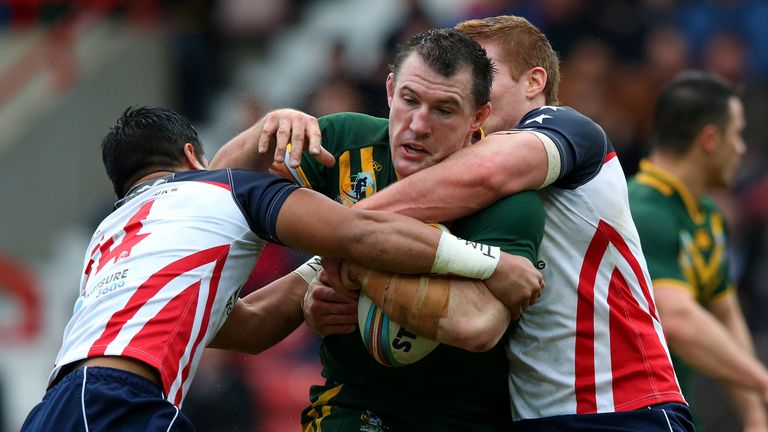 Paul Gallen of Australia is tackled by Mark Offerdahl and Tuisegasega Samoa of USA during the Rugby League World Cup Quarter Final match between Australia and USA at Racecourse Ground on November 16, 2013 in Wrexham, Wales.