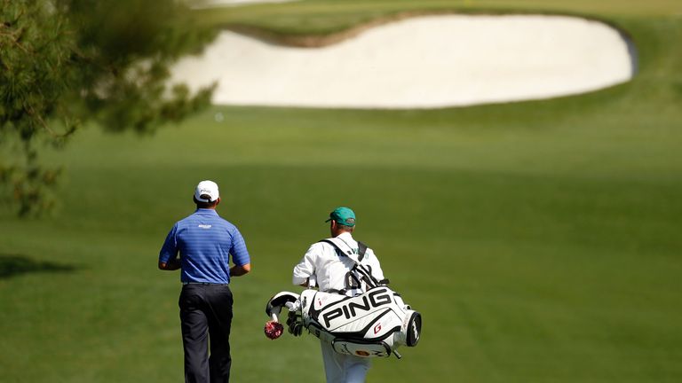 Lee Westwood of England and his caddie Billy Foster walk down the fairway during the third round of the 2012 Masters Tournament
