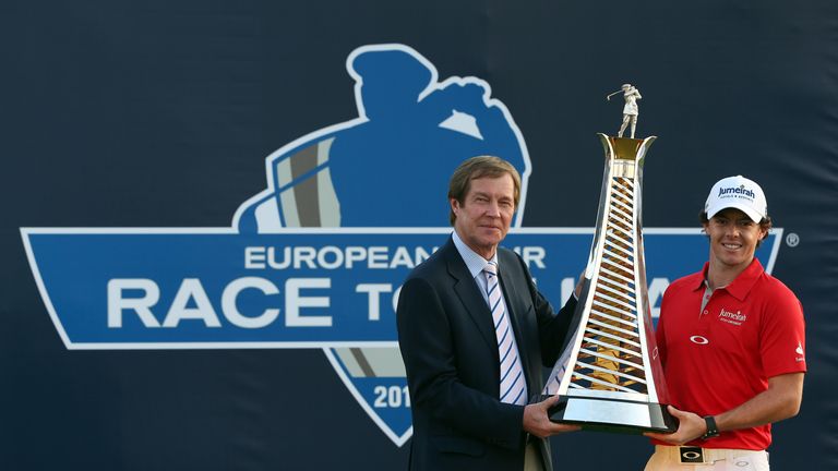 Rory McIlroy of Northern Ireland (R) poses with the Race To Dubai trophy next to George O'Grady, Chief Executive of The European Tour, after winning the DP World Tour Championship on the Earth Course at Jumeirah Golf Estates