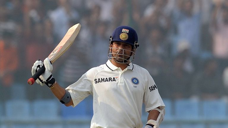 India's Sachin Tendulkar raises his bat after his half century (50 runs) during the fourth day of the first cricket test match between India and the West Indies at the Feroz Shah Kotla stadium in New Delhi on November 9, 2011