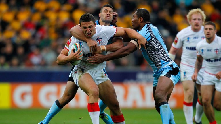 Sam Burgess is tackled by Daryl Millard and Petero Civoniceva (R)