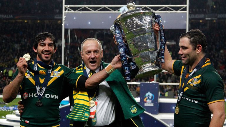 Head coach Tim Sheens (C) of Australia celebrates with the trophy with his players, Johnathan Thurtson (L) and Cameron Smith (R), after the Rugby League World Cup final between New Zealand and Australia at Old Trafford