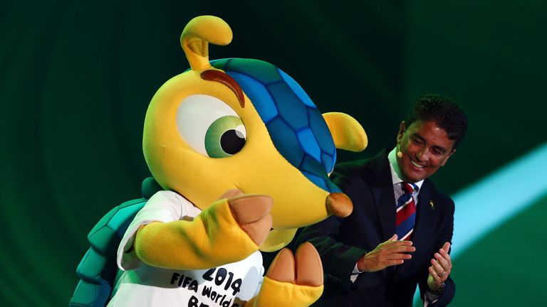 COSTA DO SAUIPE, BRAZIL - DECEMBER 06:  Bebeto performs his famous goal celebration with the official mascot, Fuleco during the Final Draw for the 2014 FIF