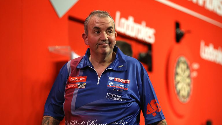 Phil Taylor reacts as he walks off the stage after losing his second round match to Michael Smith at the 2014 PDC World Darts Championship