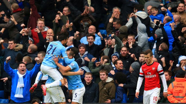 Manchester City: Manuel Pellegrini's side celebrate while Jack Wilshere looks dejected