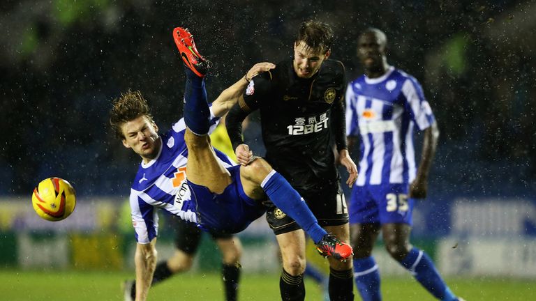 Glenn Loovens of Sheffield Wednesday and Nick Powell of Wigan challenge for the ball.