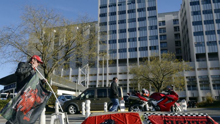Schumacher fans leave flags outside the hospital