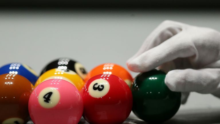  A referee racks the balls ahead of play in a pool match