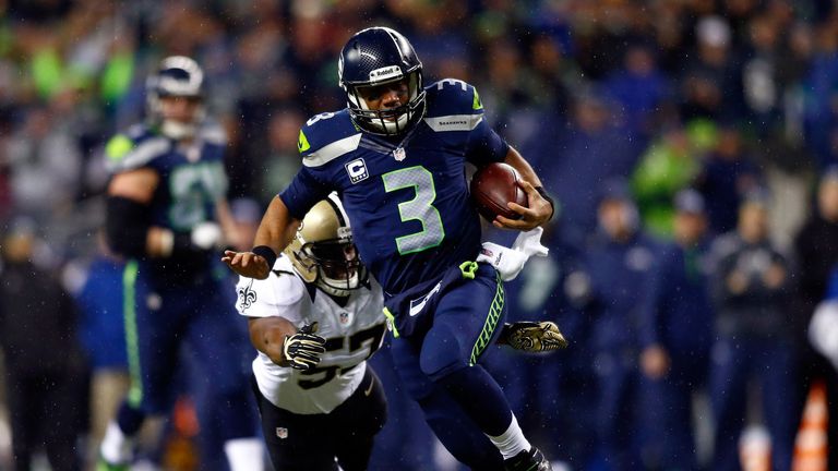 Quarterback Russell Wilson #3 of the Seattle Seahawks runs with the ball as outside linebacker David Hawthorne #57 of the New Orleans Saints defends during a game at CenturyLink Field on December 2, 2013 in Seattle, Washington