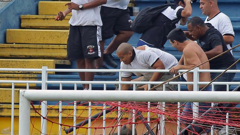 Fans of Rio de Janeiro's Vasco da Gama attack a fan of Parana's Atletico PR, during a Brazilian Championship football match in Joinville, Santa Catarina, o