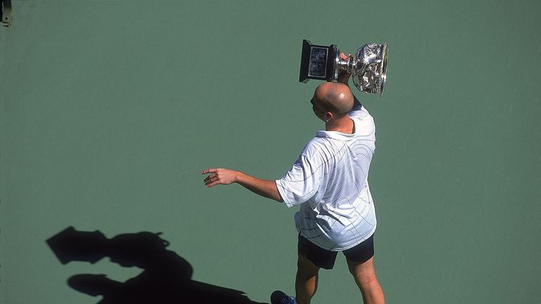 Andre Agassi of the USA lifts the trophy up after the 2001 Australian Open 