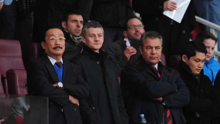 Molde manager Ole Gunnar Solskjaer (2L) and Cardiff City owner Vincent Tan (L) look on from the stands prior to the game between Arsenal and Cardiff