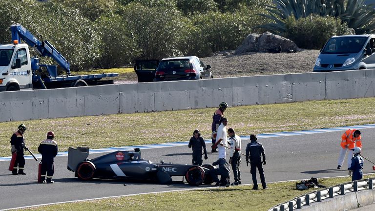 Adrian Sutil inspects his crashed car