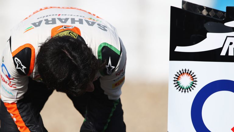 Sergio Perez examines the rear of his new VJM07 after stopping on track