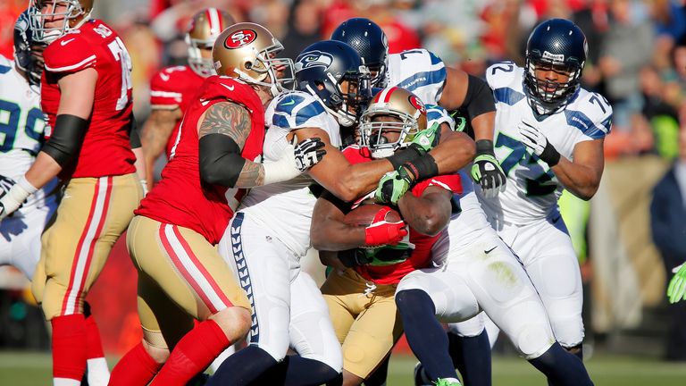 Running back Frank Gore of the San Francisco 49ers gets ganged up on by Seattle Sehawks