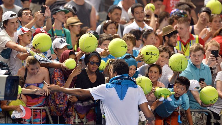 Jo-Wilfried Tsonga signs autographs following his victory over Thomaz Bellucci in their men's singles second round match on day four of the Australian Open