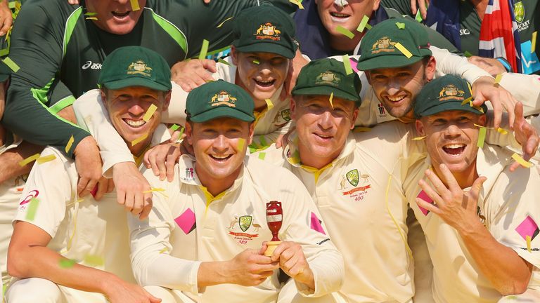 Skipper Michael Clarke (holding urn celebrates Australia's 5-0 Ashes win with his team-mates.