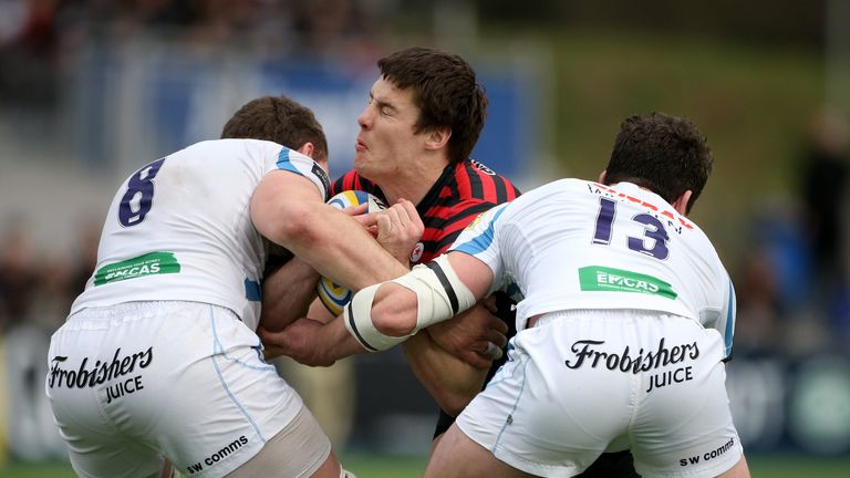 Joel Tomkins of Saracens is tackled by Dave Ewers and Ian Whitten of Exeter during the Aviva Premiership match
