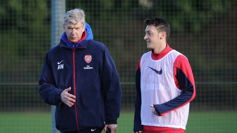 ST ALBANS, ENGLAND - DECEMBER 22:  Manager Arsene Wenger of Arsenal talks with Mesut Oezil during a training session at London Colney on December 22, 2013 