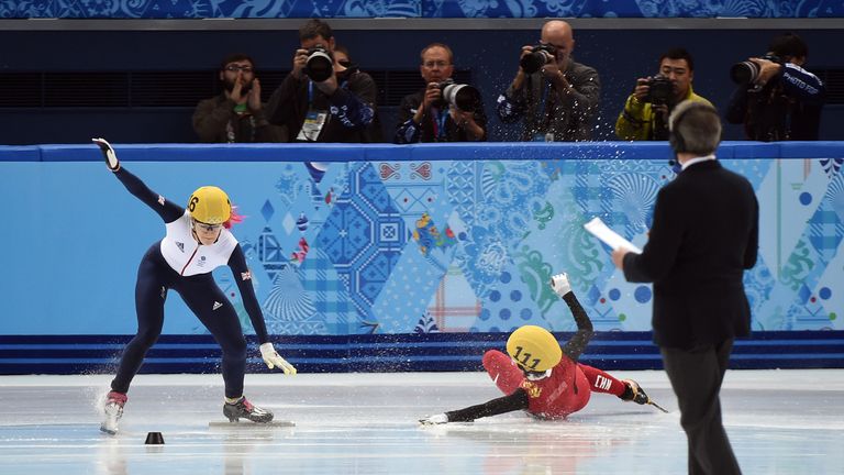 Great Britain's Elise Christie (L) and China's Li Jianrou (C) fall as they compete in the Women's Short Track 1000 m Semifinals