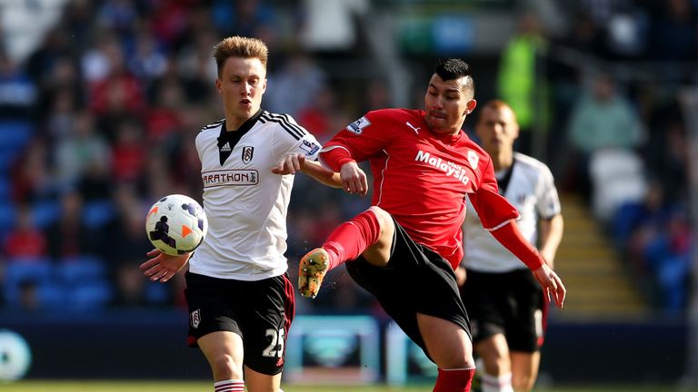 Cauley Woodrow of Fulham holds off Gary Medel of Cardiff City 