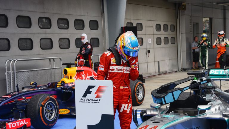 Fernando Alonso checks out Lewis Hamilton's Mercedes