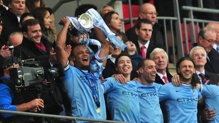 Manchester City's Belgian defender Vincent Kompany raises the League Cup during the presentation after Manchester City won the League Cup final football ma