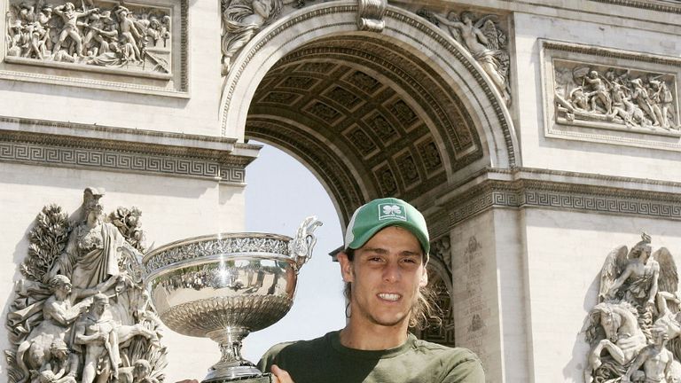 - French Open Winner Gaston Gaudio of Argentina poses with the Rolland Garros trophy in front of the Arc de Triomphe on June 7, 2004 in Paris, France.