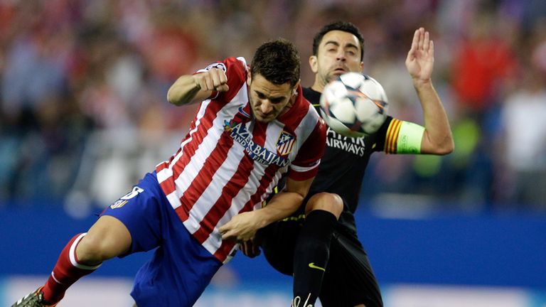 Atletico's Koke, left, fights for the ball with Barcelona's Xavi Hernandez