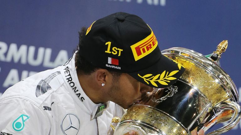 Lewis Hamilton kisses his trophy