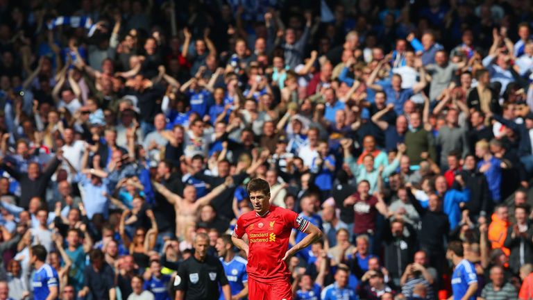 LIVERPOOL, ENGLAND - APRIL 27:  A dejected Steven Gerrard of Liverpool looks on as the Chelsea fans celebrate after Willian of Chelsea scored their second 